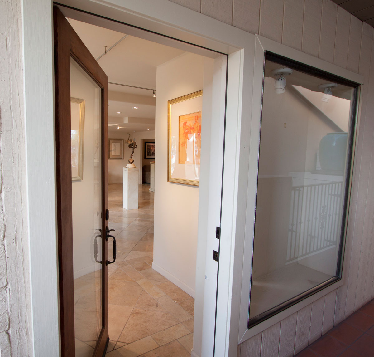 Front door off covered walkway—close to sidewalk, weather-protected.