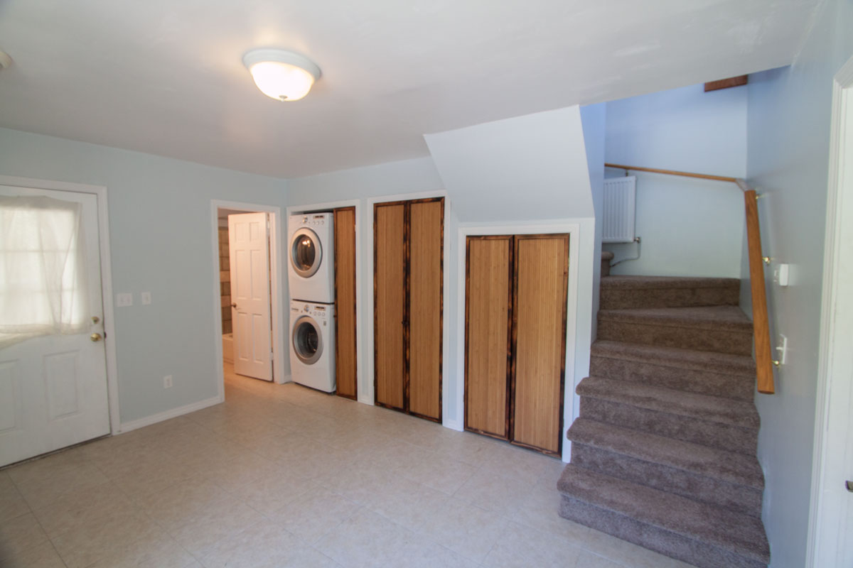 Looking from the other end of the room there is a full bathroom, washer and dryer and storage.