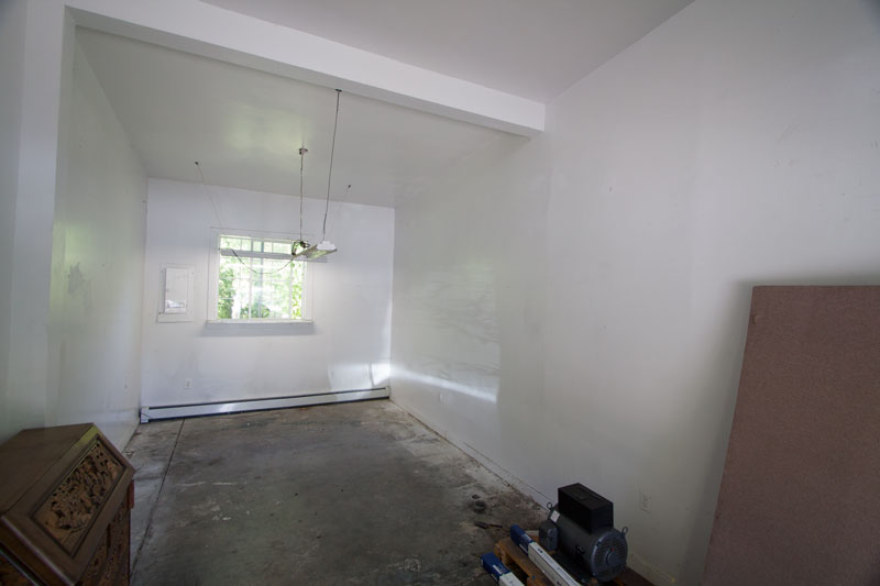 Bay 4 interior during transition — shows cement floor and white walls.